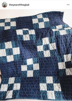 a blue and white quilt with squares on it