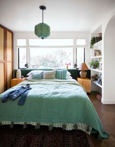 a bedroom with green bedding and pillows