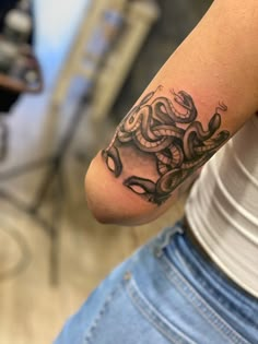 a woman's arm with a tattoo on it and a snake in the middle