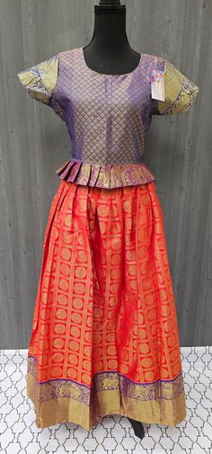 Introducing our stunning Pattu Pavadai - a South Indian traditional lehenga set - in a size 38, perfect for girls. Measuring 18 inches in blouse length, this set features a beautiful range of colorful fabrics and designer lehengas to choose from. Made from high-quality pattu material, our kids lehenga choli set is both comfortable and elegant, ensuring your young lady looks her best for any occasion. Shop our range of designer lehengas for girls now to add a touch of traditional charm to your ch Fitted Sharara With Tilla For Festive Occasions, Fitted Festive Sharara With Tilla Detail, Festive Fitted Sharara With Tilla, Traditional Sleeveless Anarkali Set With Pallu, Traditional Sleeveless Lehenga For Eid, Traditional Pink Sleeveless Set, Semi-stitched Skirt Set With Pallu For Navratri, Semi-stitched Sleeveless Art Silk Sets, Traditional Sleeveless Red Sets