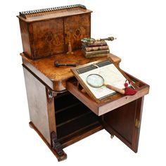 an old wooden desk with books and a magnifying glass on it's top