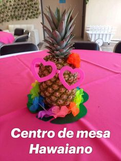 a pineapple sitting on top of a pink table cloth with hearts in the middle