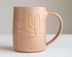 a ceramic mug with a cactus design on it