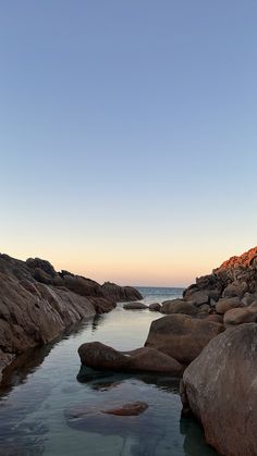 there is a small stream running between two large rocks in the water that are connected to each other