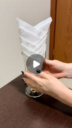 a woman is holding a tissue roll on top of a table