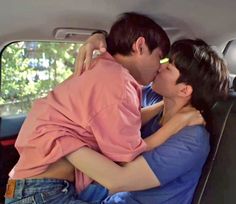 a man and woman kissing in the back of a car