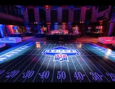 an indoor sports field lit up at night with the new york mets logo on it