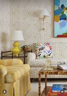 a living room filled with furniture and a painting on the wall above it's coffee table