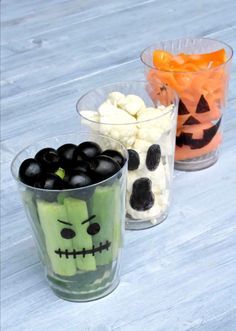 three plastic cups with halloween treats in them