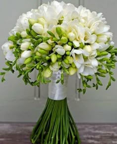 a bouquet of white flowers sitting on top of a wooden table