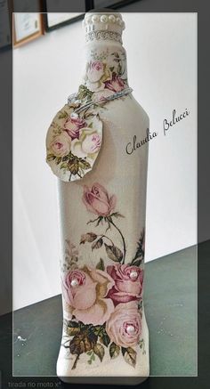 a white vase with pink roses painted on it