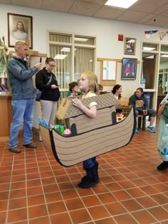 a group of people standing in a room with a boat on it's back