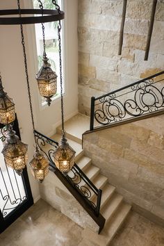 the chandelier is hanging from the stair railing