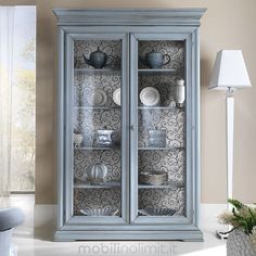 a blue china cabinet with glass doors in a living room