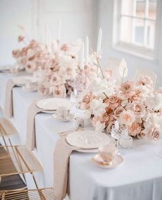 the table is set with white and pink flowers