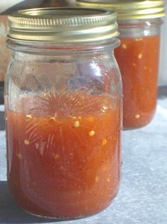 two jars filled with liquid sitting on top of a table