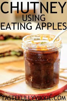 a glass jar filled with food sitting on top of a wooden cutting board next to a knife