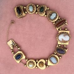 Beautiful Retro era bracelet, circa 1940s, 7.25 inch long, weighting 38.3 gram Larger charm at 3/4 inch wide on center tapered down to smaller charms of 1/2 inch bracelet width stones and cameos show wear and tear, see pictures Authentic American Jewelry marked 14 Karat Vintage 14k Gold Bracelet, Vintage 14k Gold Jewelry Bracelet, Luxury Collectible Retro Jewelry, Vintage Oval 14k Gold Bracelet, Antique Oval Gold Bracelet, Vintage 14k Gold Oval Bracelet, Antique Gold Bracelets With Vintage Charm, Vintage Cameo Bracelet Jewelry, Vintage Cameo Bracelet