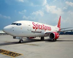 an airplane sitting on the tarmac with its wheels down and it is red and white