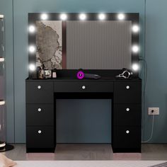 a black vanity with lights on it and a mirror behind it in a room that is blue