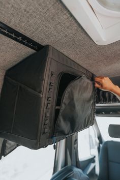 the back compartment of a vehicle with luggage hanging from it's roof rack and door open