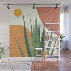 an orange and yellow wall mural with green plants in the foreground, on a wooden floor next to a white chair