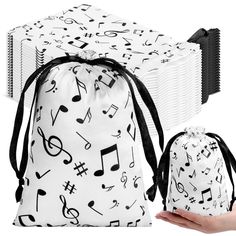 a white bag with musical notes on it and a hand holding an accordion in front of it