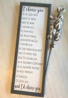 there is a framed poem on the floor next to some cotton stalks and a flower