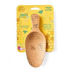 a wooden spoon with bees on it next to a packaged package for the brand's product