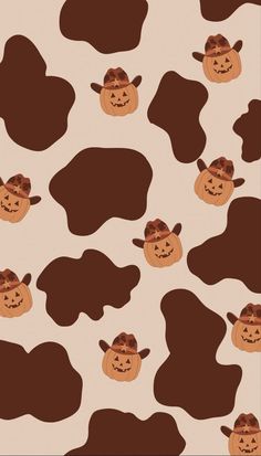 a cow pattern with pumpkins and cowboy hats on it's head, as if for halloween