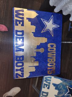 a blue and gold book sitting on top of a wooden table next to other books