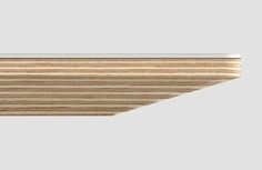 a close up of a wooden shelf on a gray background with light wood grains