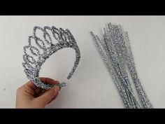 someone is making a tiara out of silver beads