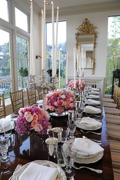 the table is set with flowers and place settings for dinner guests to sit down at