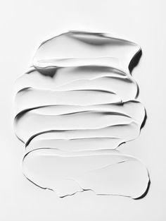 an abstract piece of white paper with wavy lines on it's surface, in the shape of waves