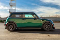 a small green car parked in a parking lot