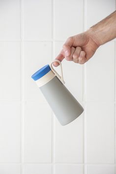 a person holding a cup in the air with their right hand on top of it