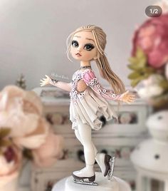 a doll is standing on top of a cake