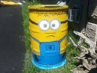 a yellow and blue trash can sitting in the grass