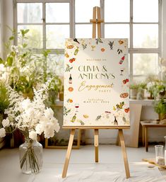 an easel with flowers in front of a sign