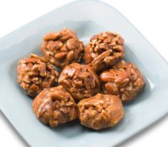 a white plate topped with cookies covered in nuts