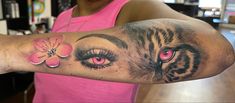 a woman with a tiger and flower tattoo on her arm is looking at the camera