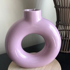 a purple vase sitting on top of a wooden stand