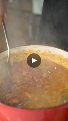 a person stirring food in a pot with a spoon