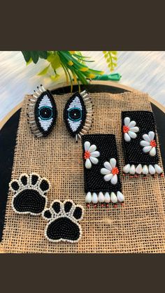 three pieces of beaded jewelry with an animal's paw and eyeballs on them