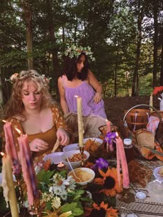 two women sitting at a table with candles