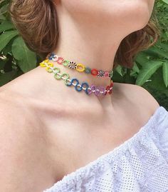 a woman wearing a multicolored beaded choker and matching necklace with an earring