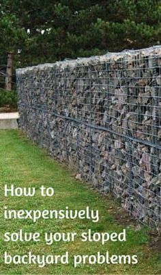 a fence made out of rocks with the words how to expensively solve your sloped backyard problems