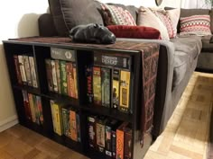 a book shelf filled with lots of books next to a couch