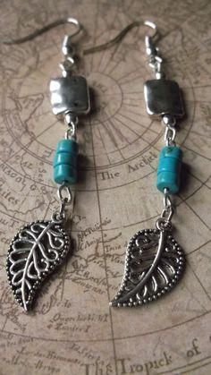 the earrings are made from silver and turquoise beads with leaf charms on each earring